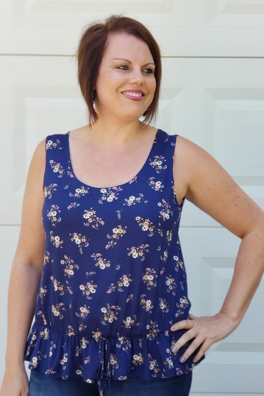 This adorable top would be perfect with your favorite pair of jeans or shorts! It is lined and includes a round neckline and an elastic self tie waistband.